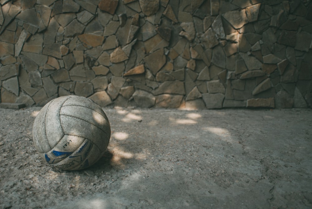 회색 콘크리트 바닥에 흰색과 파란색 축구 공