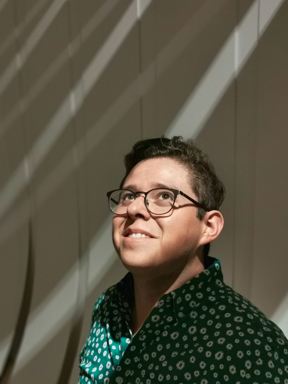 woman in green and white polka dot shirt wearing black framed eyeglasses