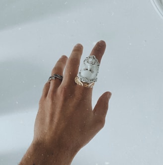 silver and diamond ring on persons finger