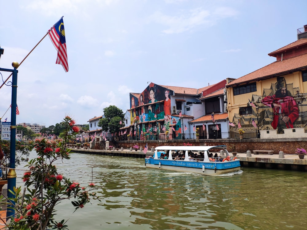 blue and white boat on water near houses during daytime