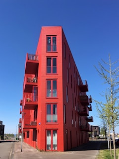 red concrete building near green trees during daytime