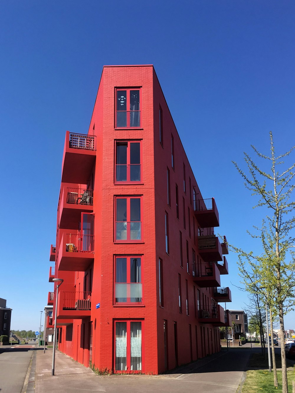 Bâtiment en béton rouge près d’arbres verts pendant la journée