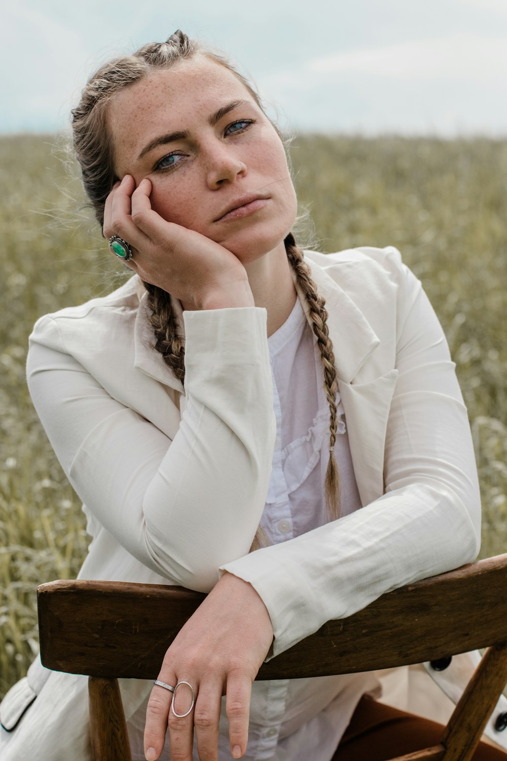 woman in white long sleeve shirt sitting on brown wooden chair