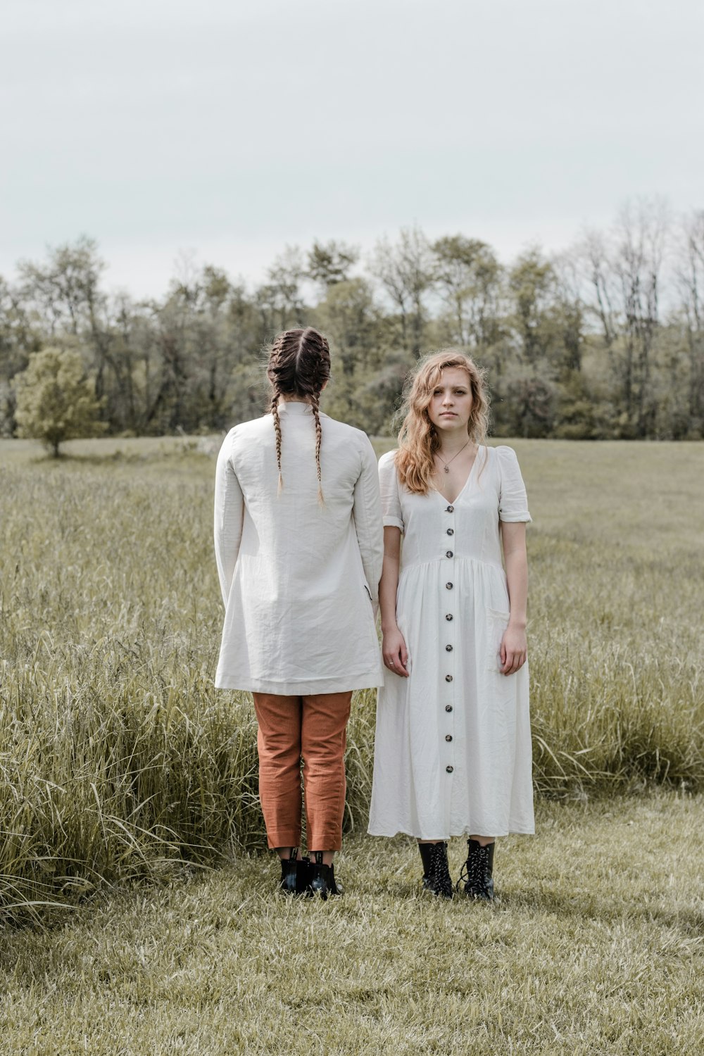 woman in white long sleeve dress standing on green grass field during daytime