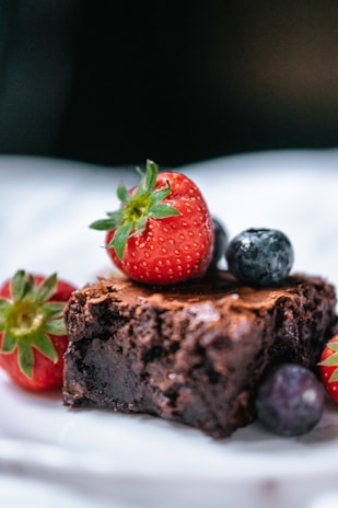 strawberry on chocolate cake on white ceramic plate