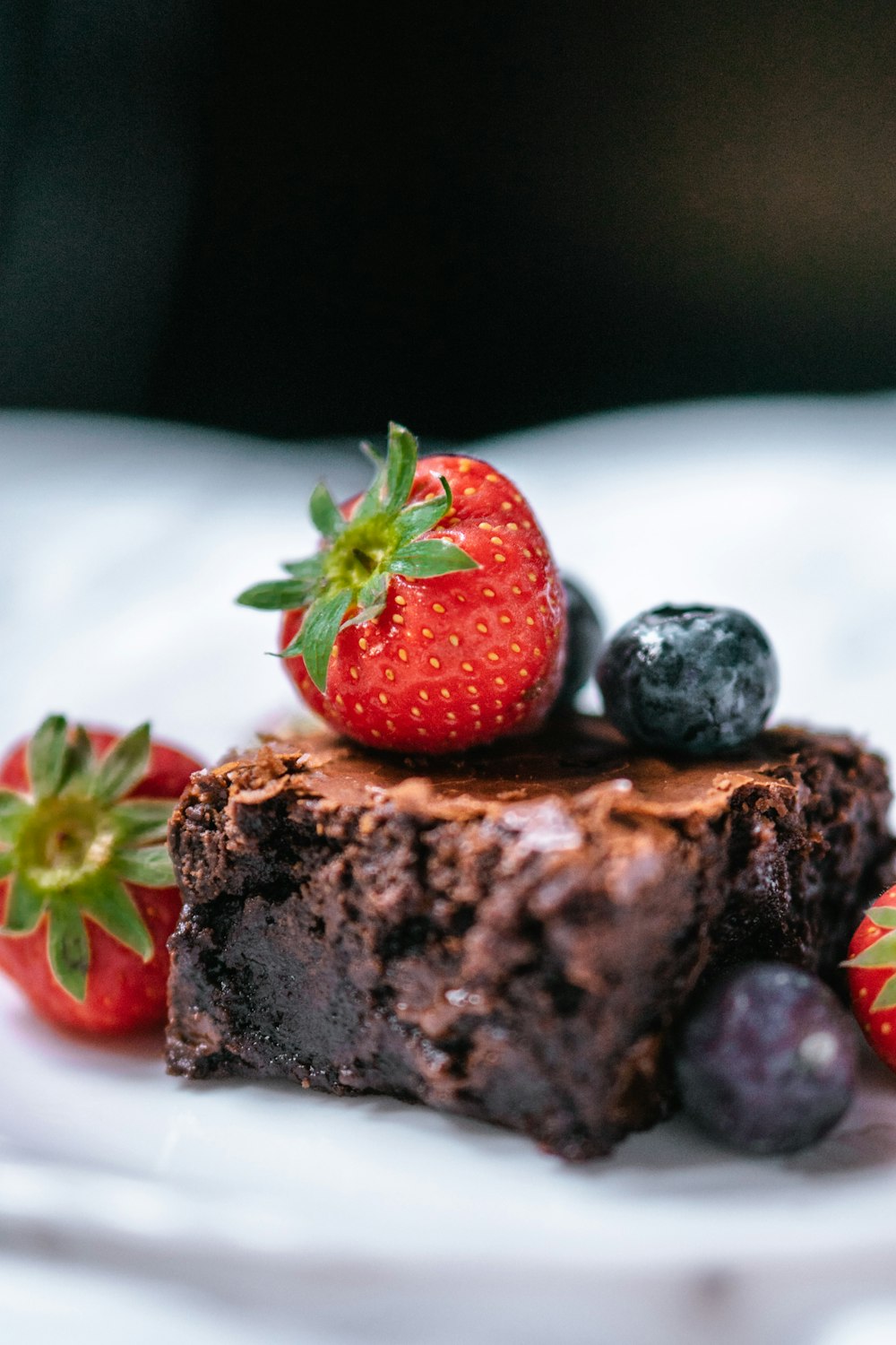 strawberry on chocolate cake on white ceramic plate