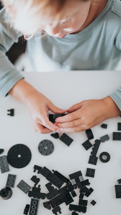 person in white long sleeve shirt holding black and white dices