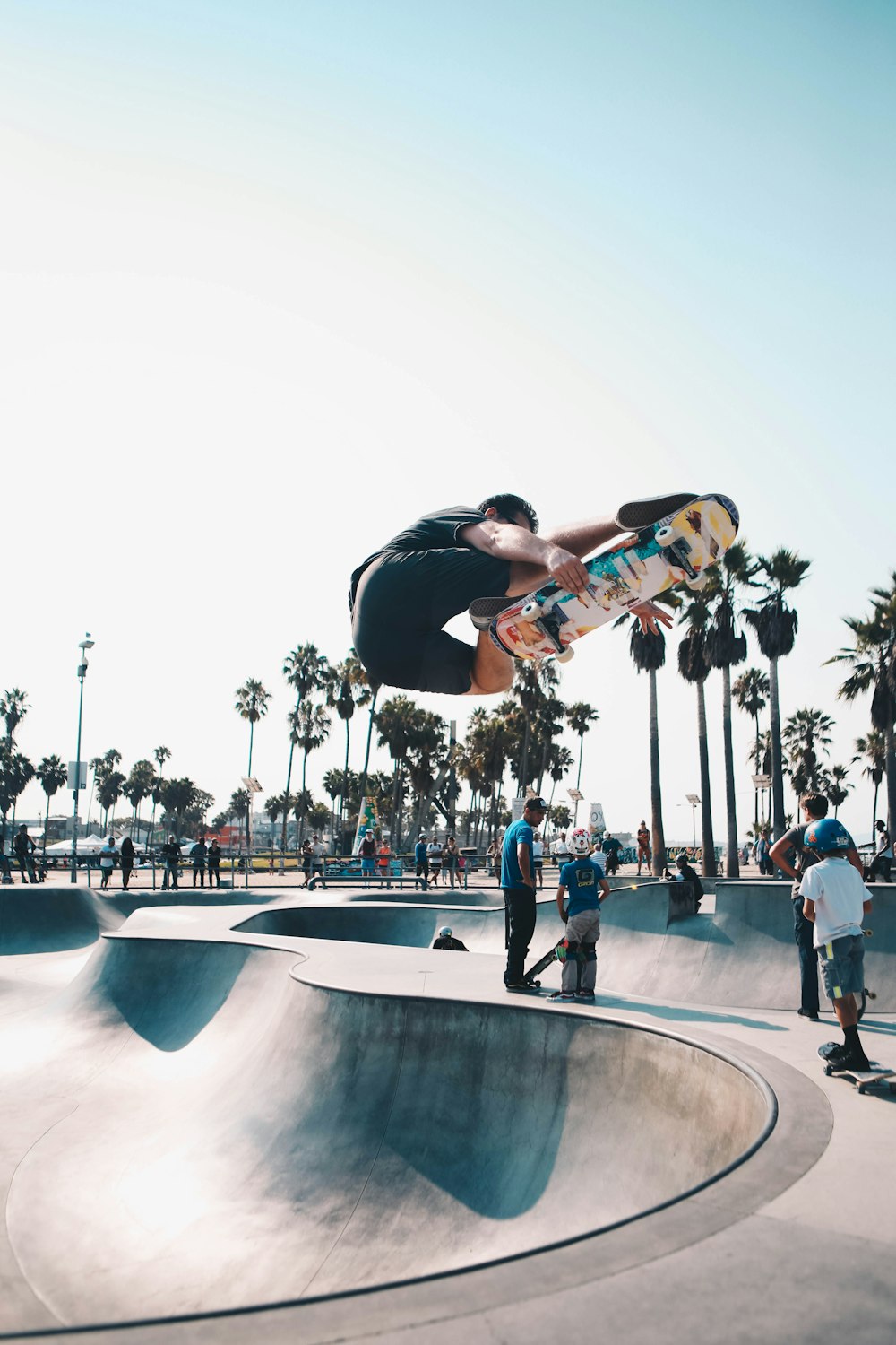 man in black shirt and blue denim jeans doing skateboard stunts on skateboard ramp
