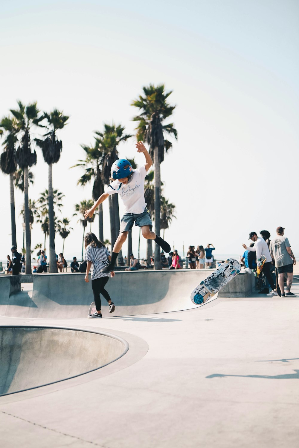 man in white t-shirt and black shorts playing skateboard