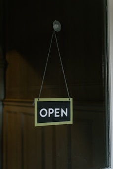 A simple closed sign hanging on the door of Paradise Takeaway, with a soft sunset in the background.