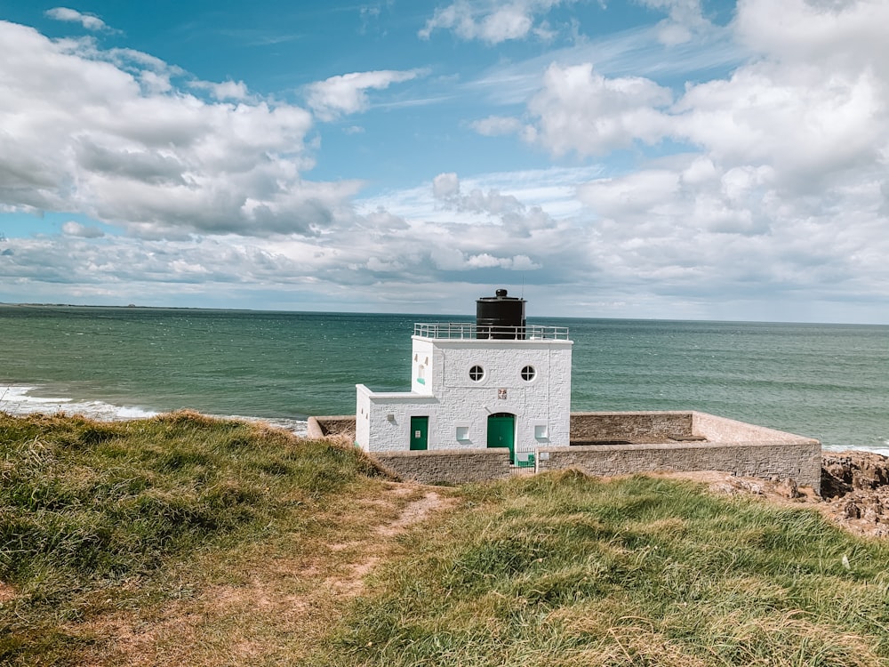 white concrete building near sea under blue sky during daytime