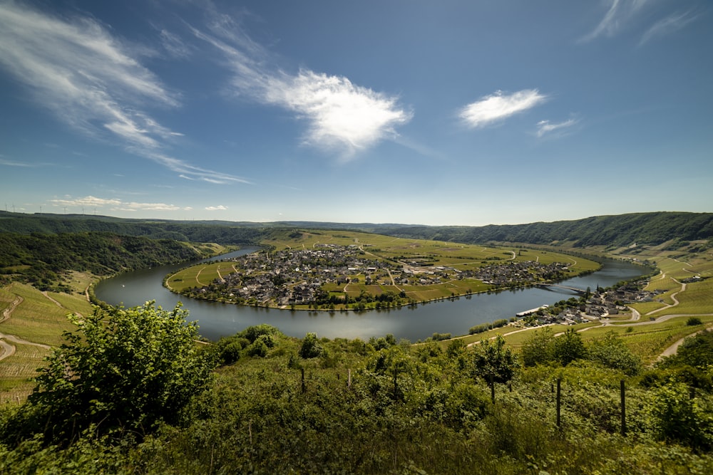 Grüne Bäume in der Nähe des Sees unter blauem Himmel während des Tages