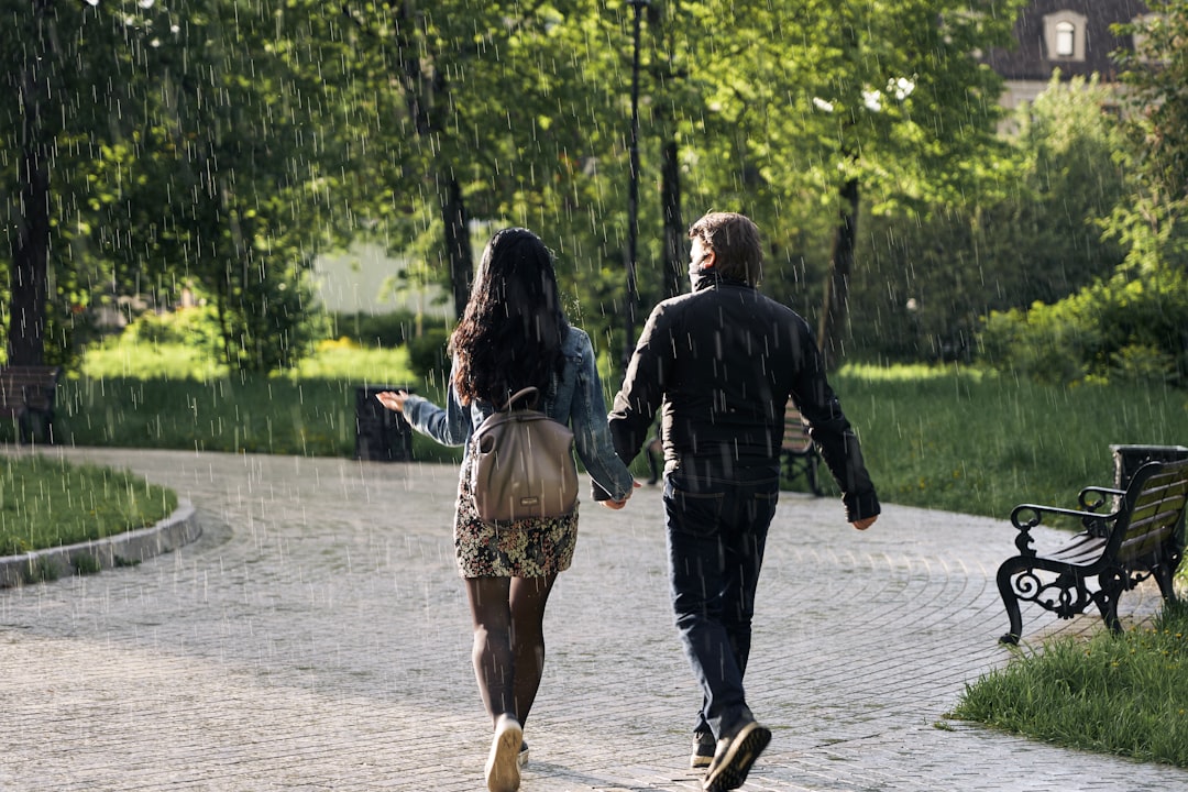 man and woman walking on gray concrete pathway during daytime