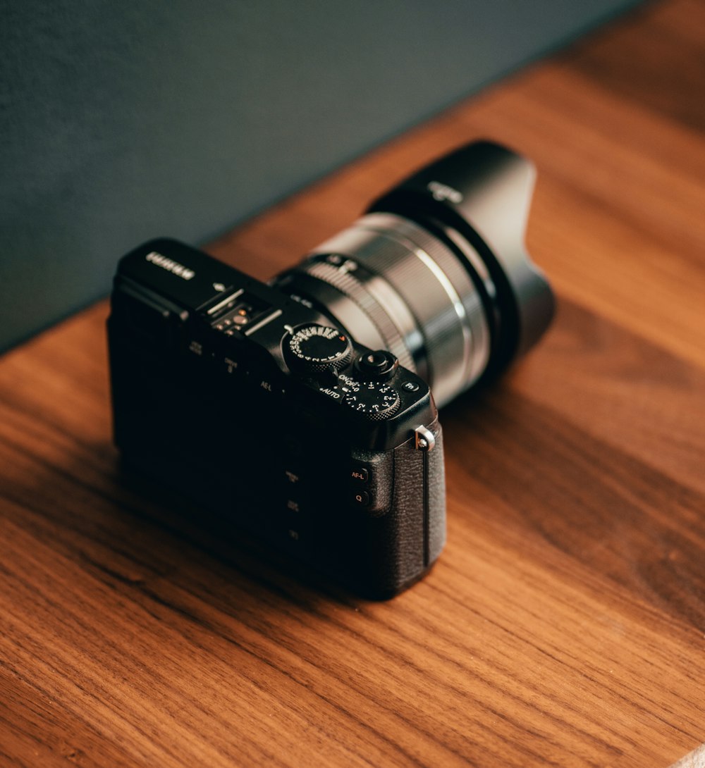 black and silver camera on brown wooden table