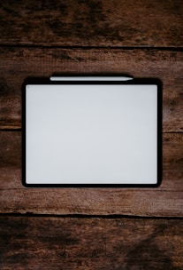 white and black tablet computer on brown wooden table