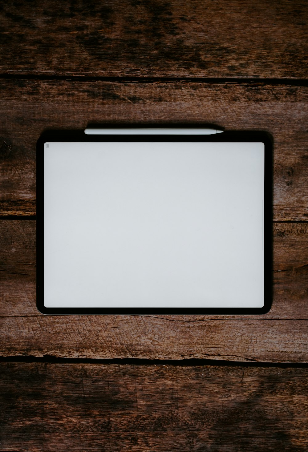 white and black tablet computer on brown wooden table