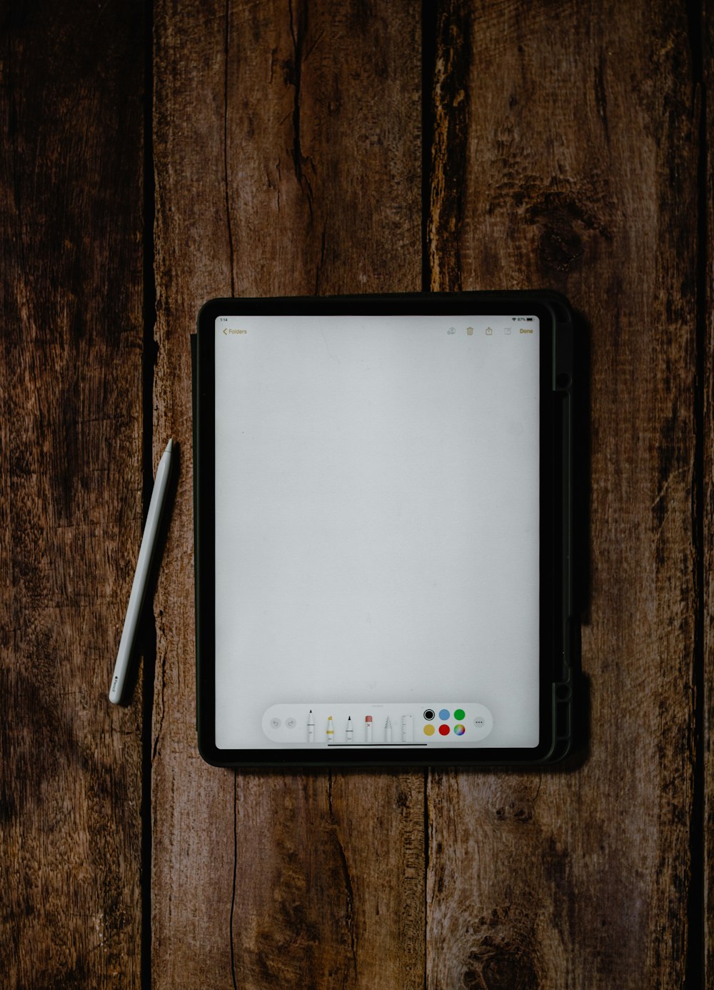 computador de tablet branco e preto na mesa de madeira marrom