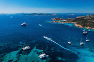 Aerial shot capturing the vibrant blue ocean and a fleet of yachts at anchor near Phuket.