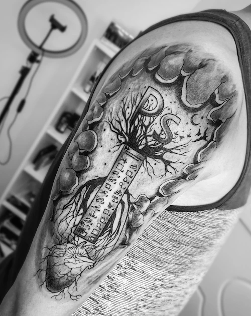 Detailed black and grey shoulder tattoo