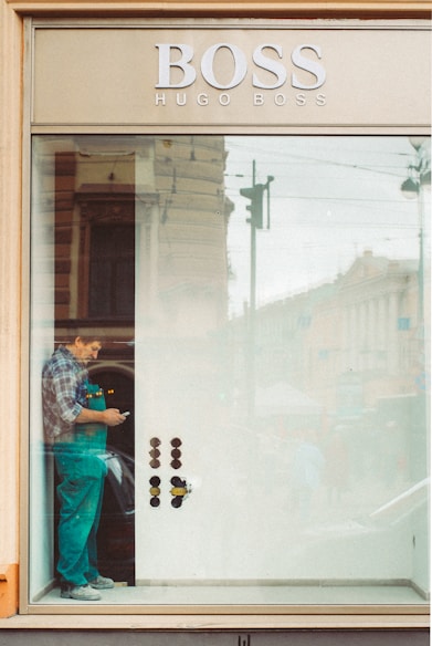 woman in blue denim jacket and blue denim jeans standing in front of glass window