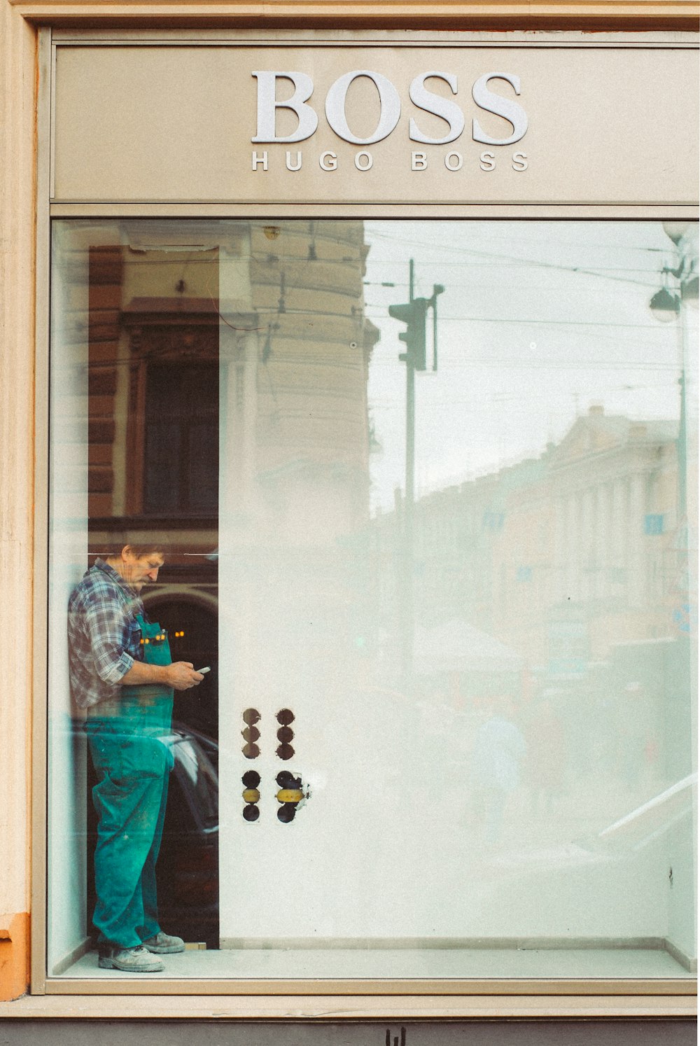ブルーデニムジャケットとブルーデニムジーンズの女性がガラ�ス窓の前に立つ