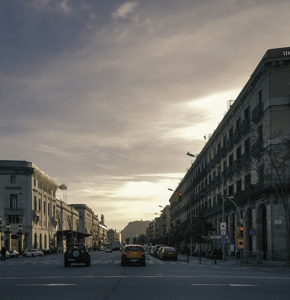 cars parked on side of the road in between buildings during daytime