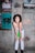 woman in white tank top and green shorts standing beside wall
