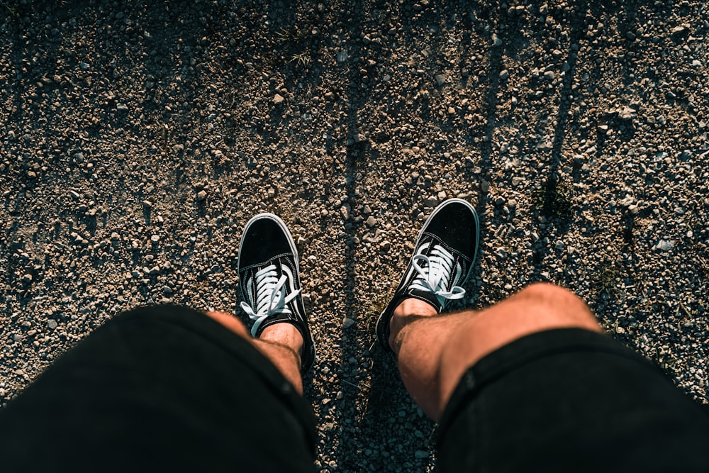 persona con zapatillas blancas y negras