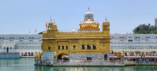 brown dome building near body of water during daytime in Harmandir Sahib India