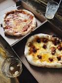 A delivery box open to reveal several hot, steaming pizzas ready for a corporate event.