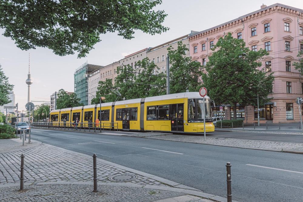 gelb-weißer Zug tagsüber auf der Bahnstrecke