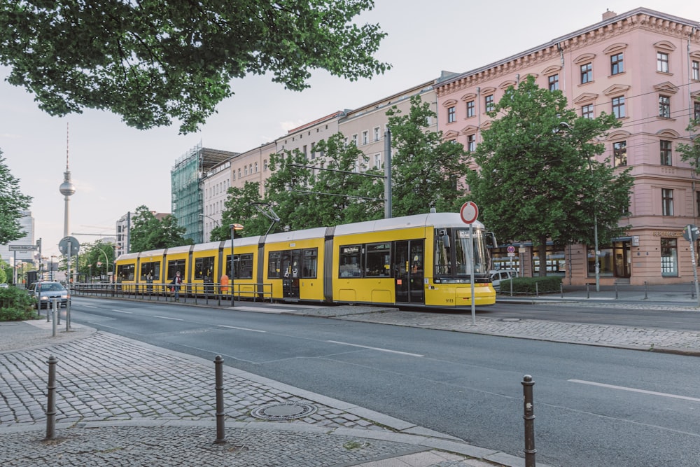 trem amarelo e branco na estrada de ferro durante o dia