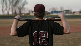 man in red and white baseball cap and black and white jersey shirt