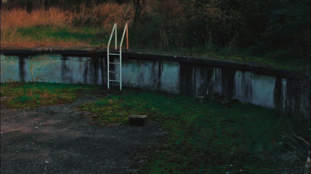 gray concrete wall near green grass field during daytime