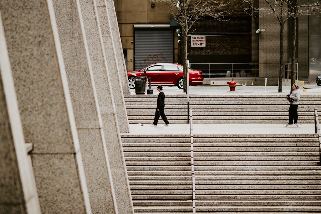 man in black jacket walking on pedestrian lane during daytime