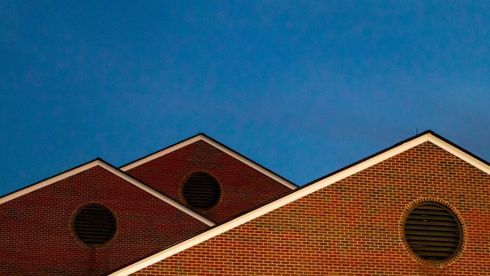 낮 동안 푸른 하늘 아래 갈색 벽돌 건물
