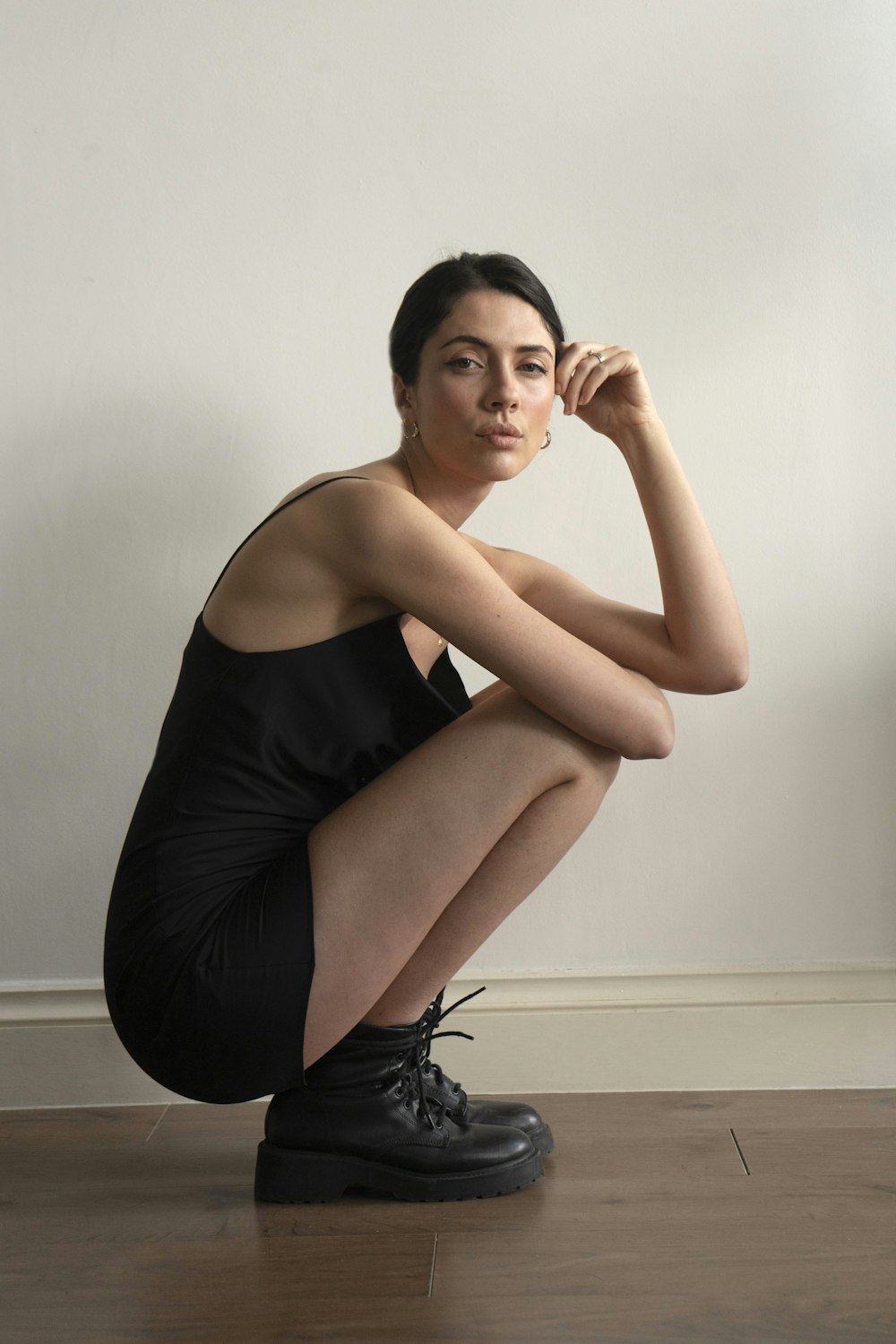 woman in black tank top and black shorts sitting on floor