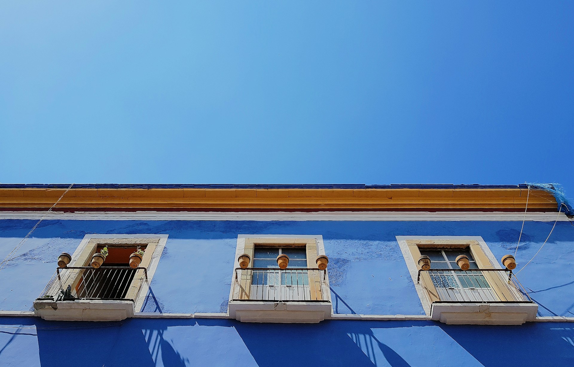 Transformation of a residential facade with fresh blue paint and new architectural details under clear sky.