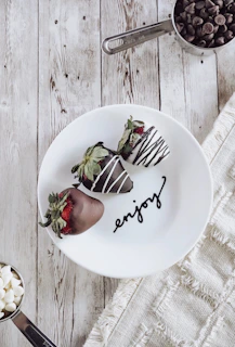 A cheerful customer enjoying a box of Dulcefresa strawberries dipped in chocolate.