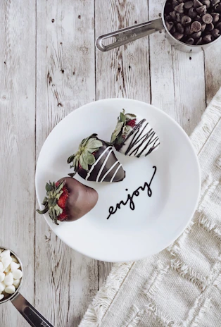 A cheerful customer enjoying a box of Dulcefresa strawberries dipped in chocolate.