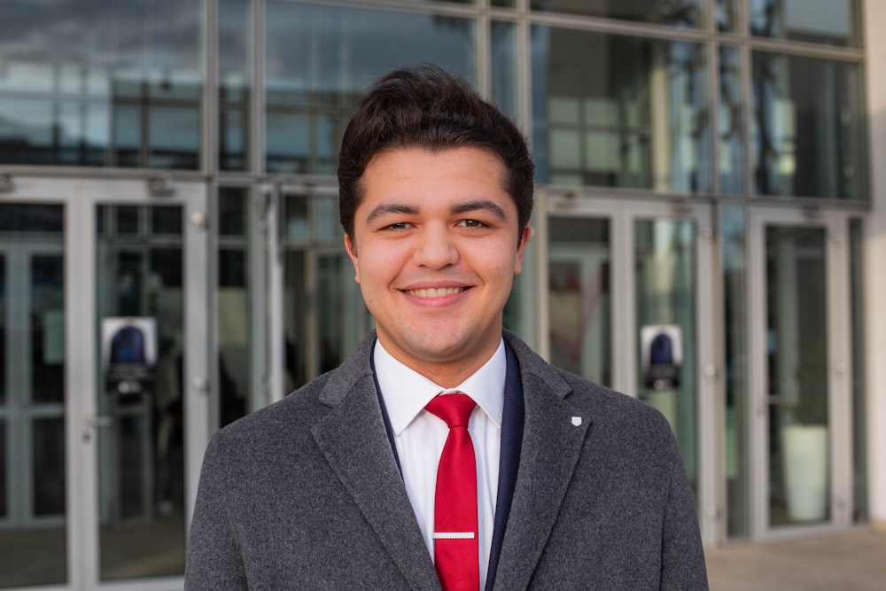 man in gray suit jacket smiling