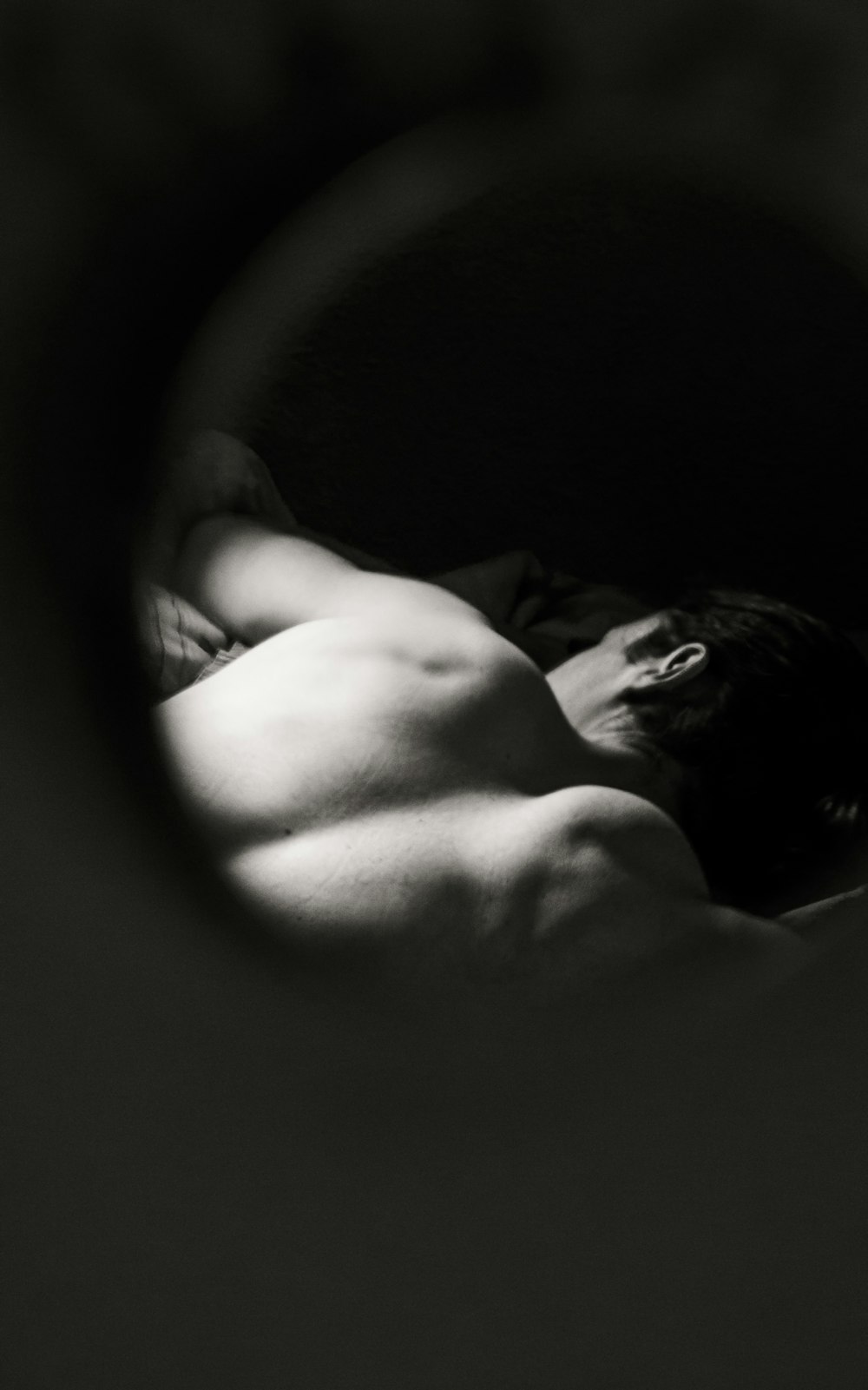 grayscale photo of woman lying on bed