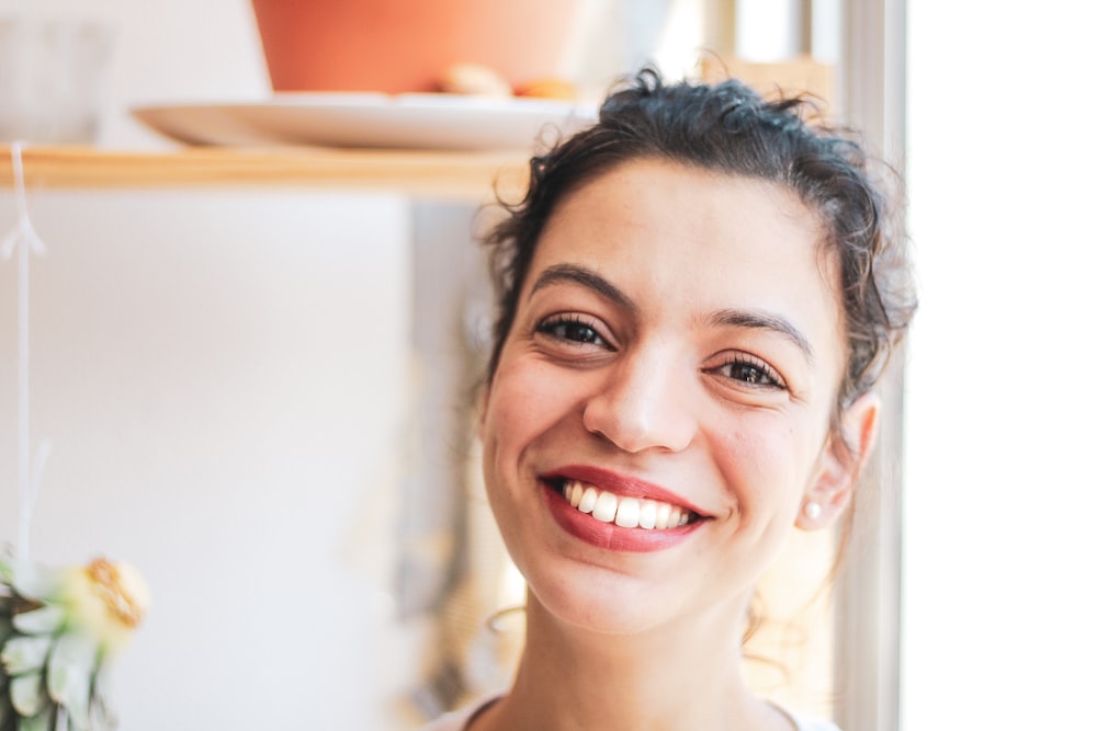 femme en débardeur blanc souriante