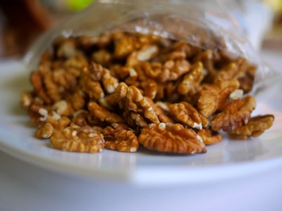 brown peanuts on clear plastic container pecan teams background