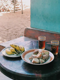 A vibrant plate of local pastries and tropical fruit on a rustic wooden table.