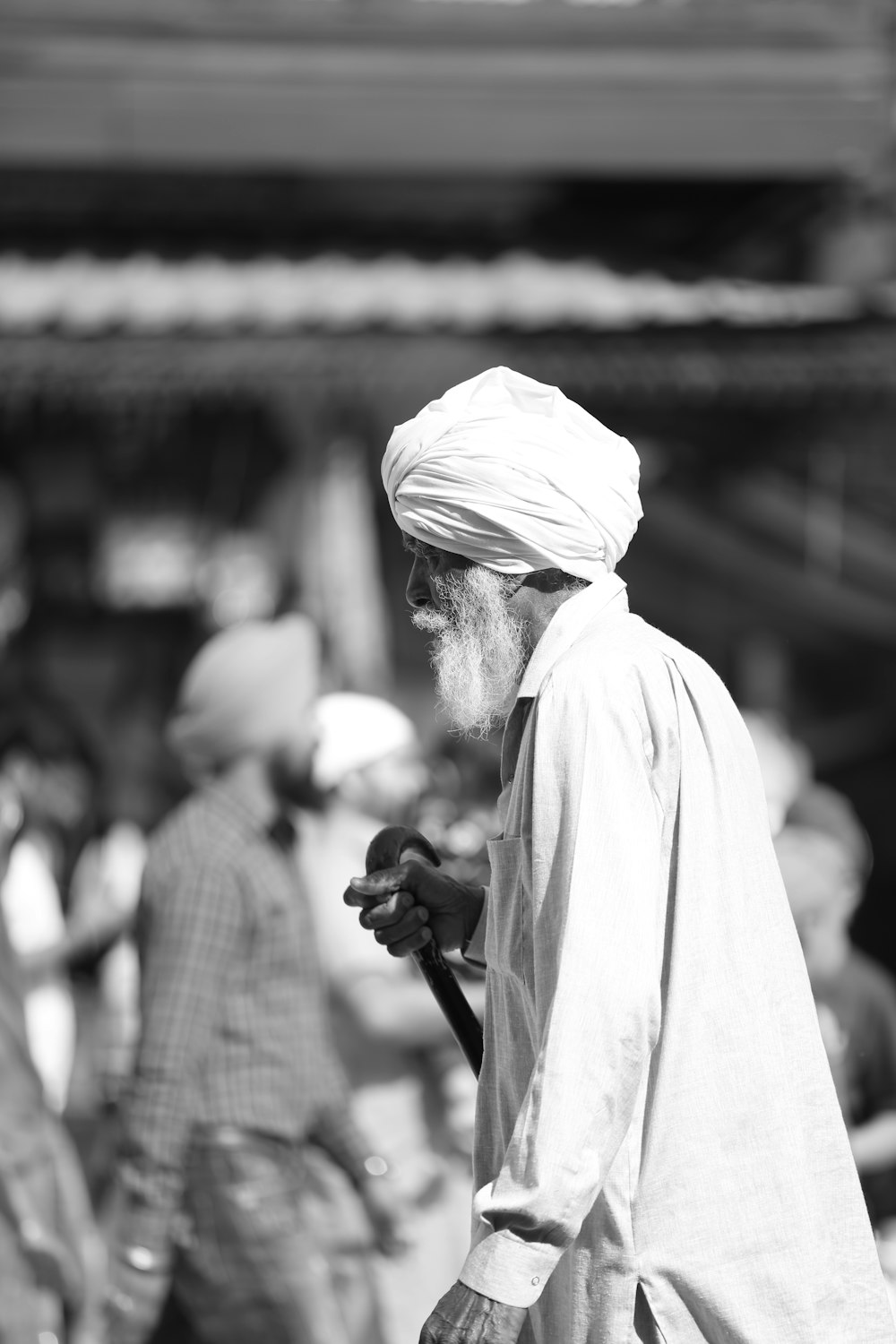 grayscale photo of man in white robe holding microphone