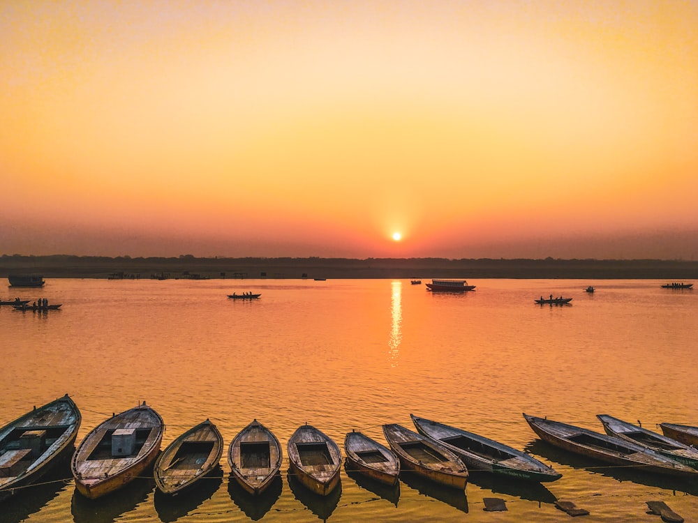 silhouette of boats on sea during sunset