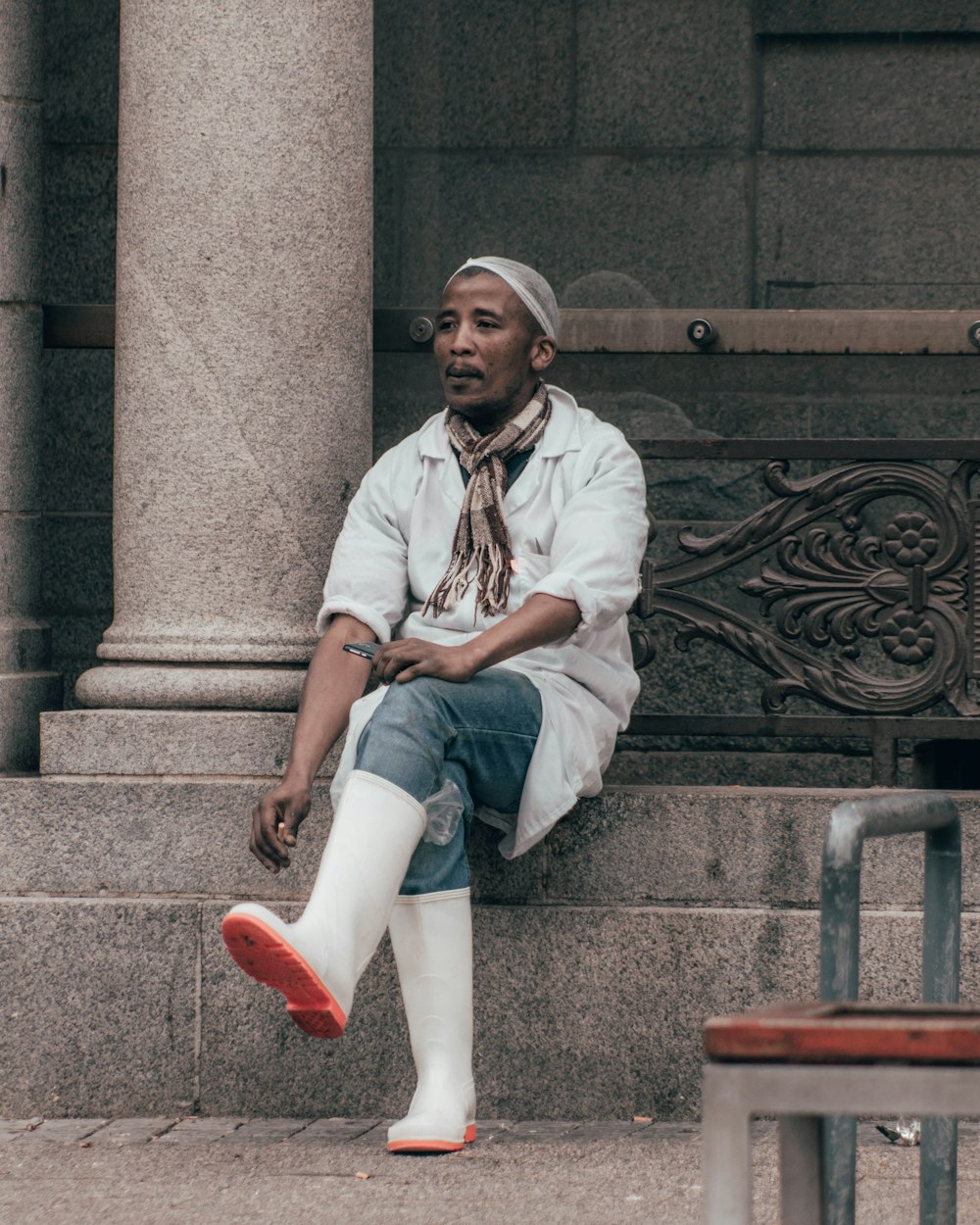 man in white and black plaid button up shirt sitting on brown wooden bench