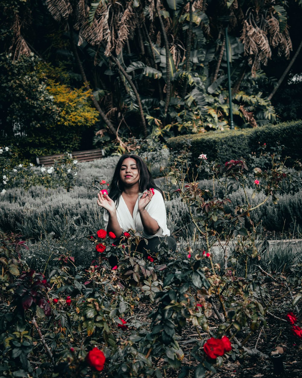 woman in white tank top sitting on green grass field