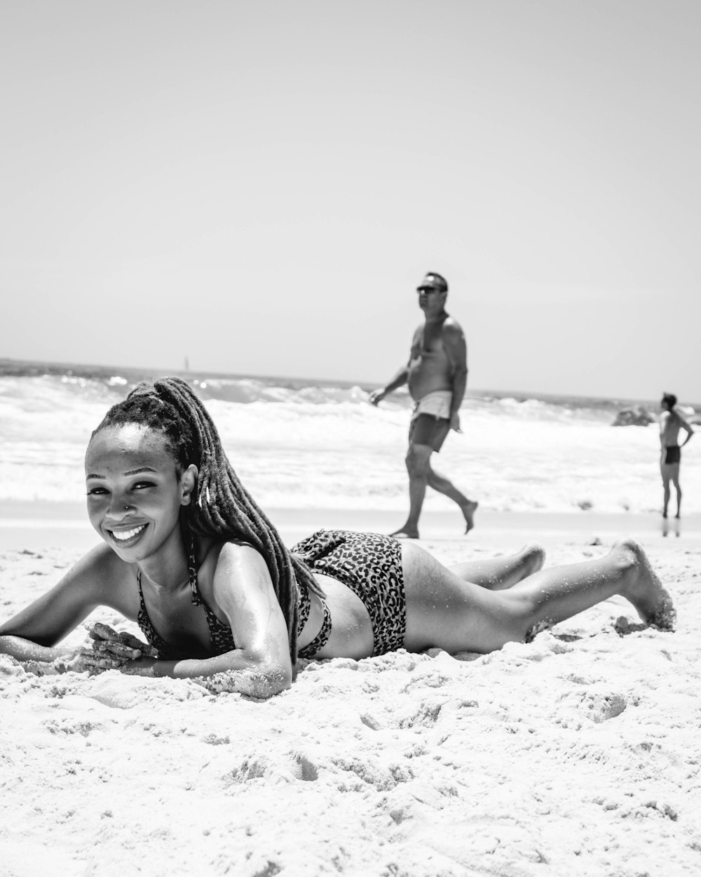 grayscale photo of 2 women sitting on beach